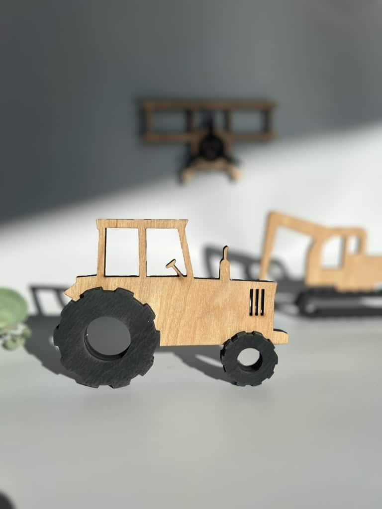 En closeup av håndlagde figurer - traktor, gravemaskin og fly.