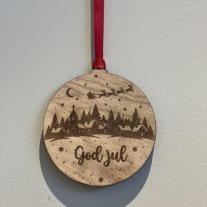 En lasergravert julekule med julenissen, reiinsdyr og God jul-motiv.