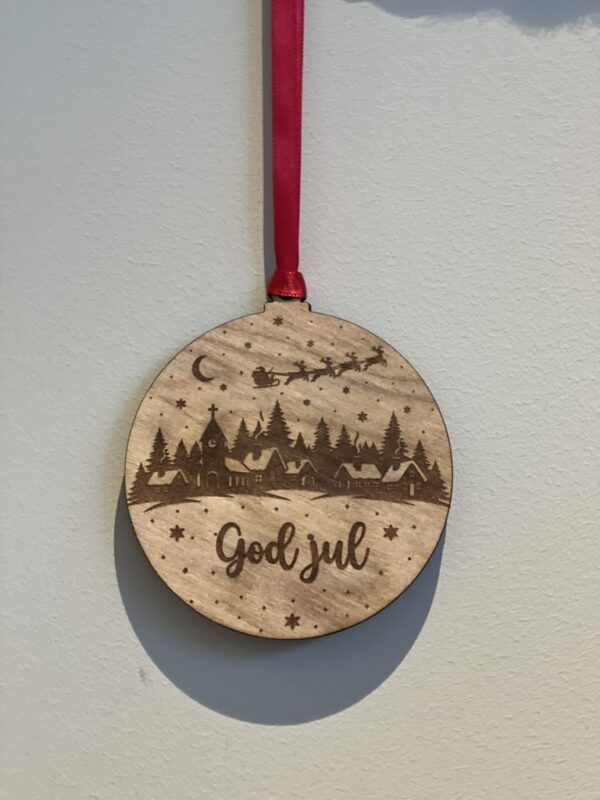 En lasergravert julekule med julenissen, reiinsdyr og God jul-motiv.