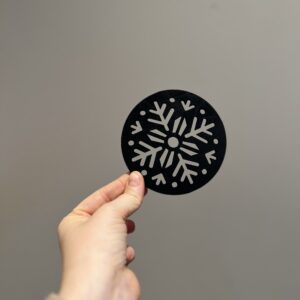 Bilde av den matte sorte baksiden på snøflak drikkeunderlag, design 1 av 2.