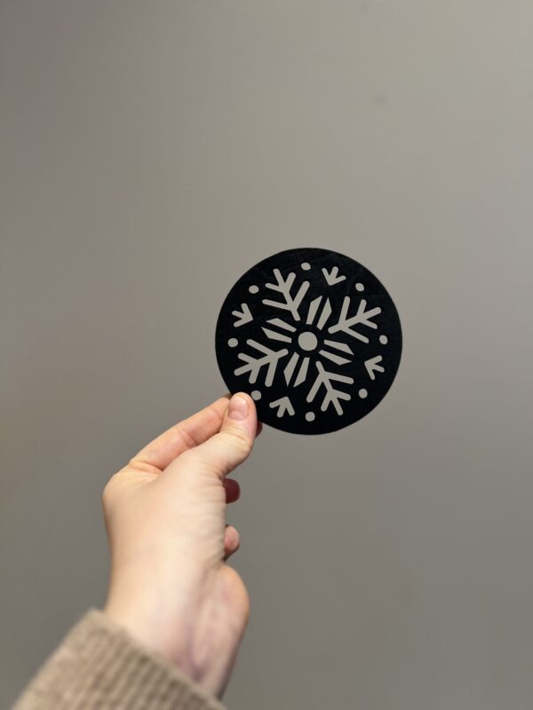 Bilde av den matte sorte baksiden på snøflak drikkeunderlag, design 1 av 2.