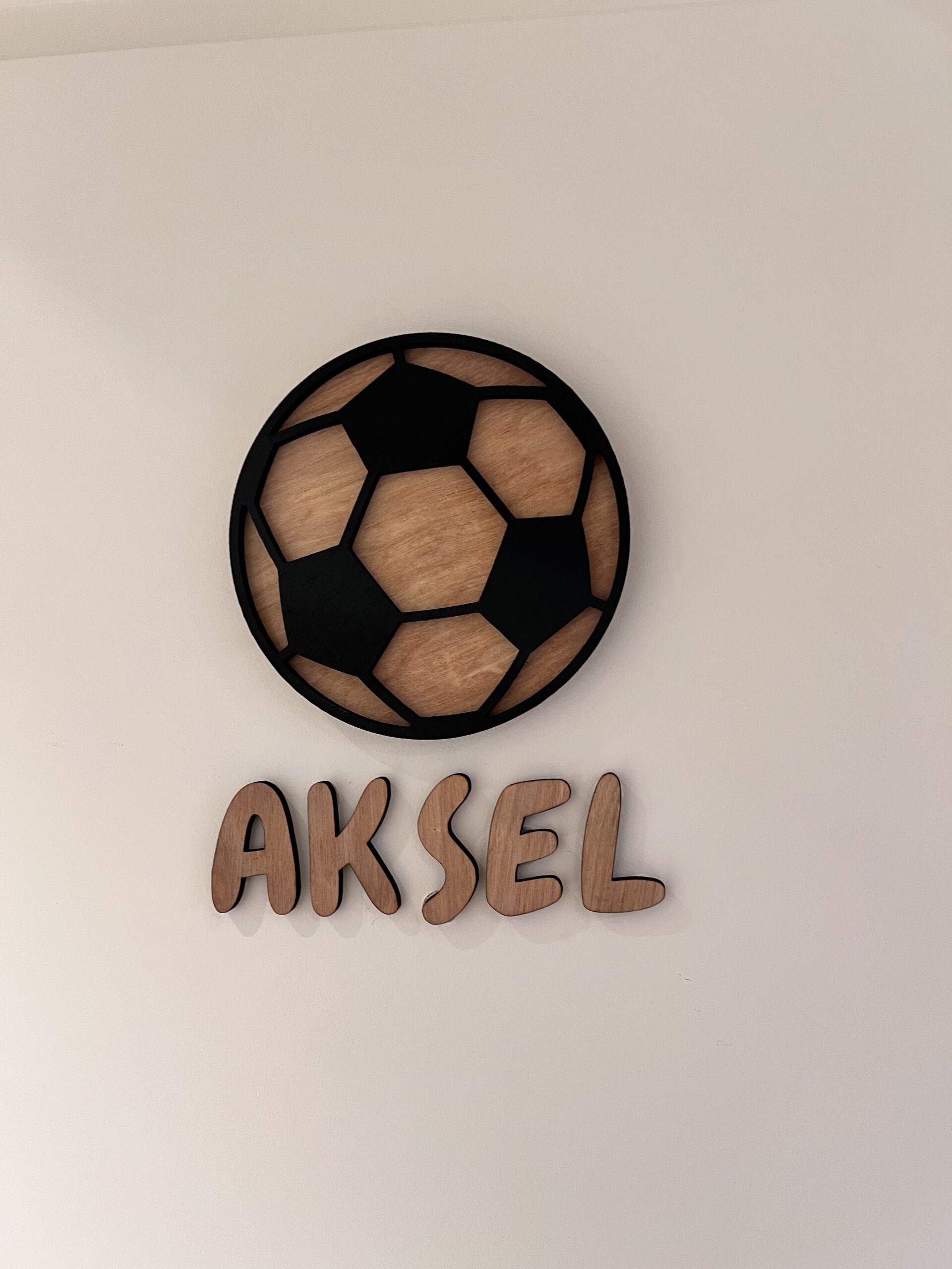Et personlig navneskilt med fotball som er håndlaget i Bergen av ByRossland.