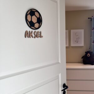 Navneskilt til barnerom med en håndlaget fotball som henger over barnets navn.