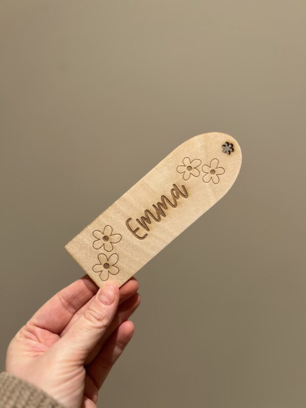 Personlig lasergravert bokmerke i 3 mm bjørkefiner med blomster og barnets navn, perfekt for barn som liker å lese.