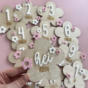 Blomsterformede milepælskort i tre med norsk tekst – perfekt til babyens første år. Også en super gaveide til babyshower, barselsgave eller til dåp og navnefest.