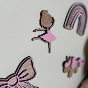 En håndlaget ballerina veggdekor sammen med andre figurer som rosa regnbue, sløyfe og enhjørning. Perfekt på barnerommet.