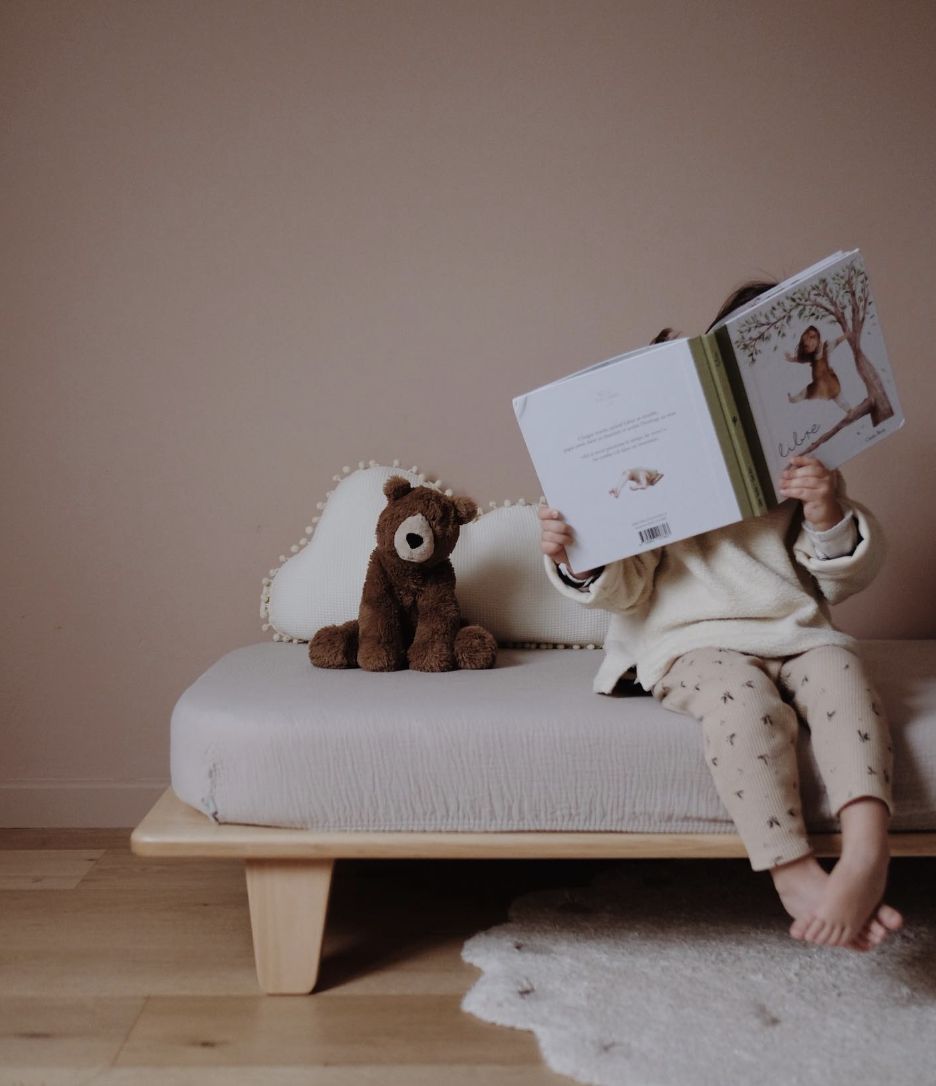 Et barn som sitter på barnerommet med en bamse og leser en bok. Bilde hentet fra Pinterest.