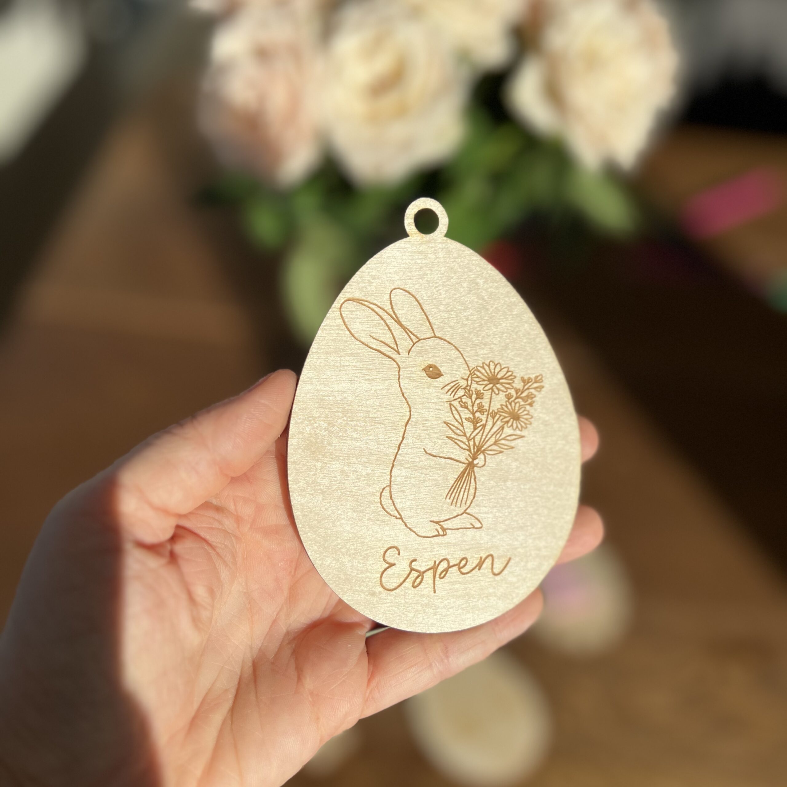 Personlig påskeornament i bjørkfiner, oval form med lasergravert kanin og blomster, med valgfritt navn eller tekst.