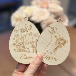 Personaliserbar påskepynt med lasergraverte kaniner og blomster, med ønsket navn.