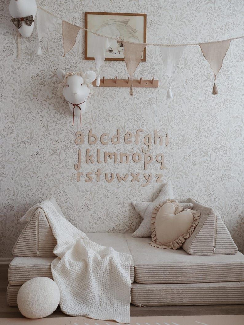 Et alfabet med bokstaver i tre som er hengt opp på barneromsveggen. Bildet hentet fra Pinterest.