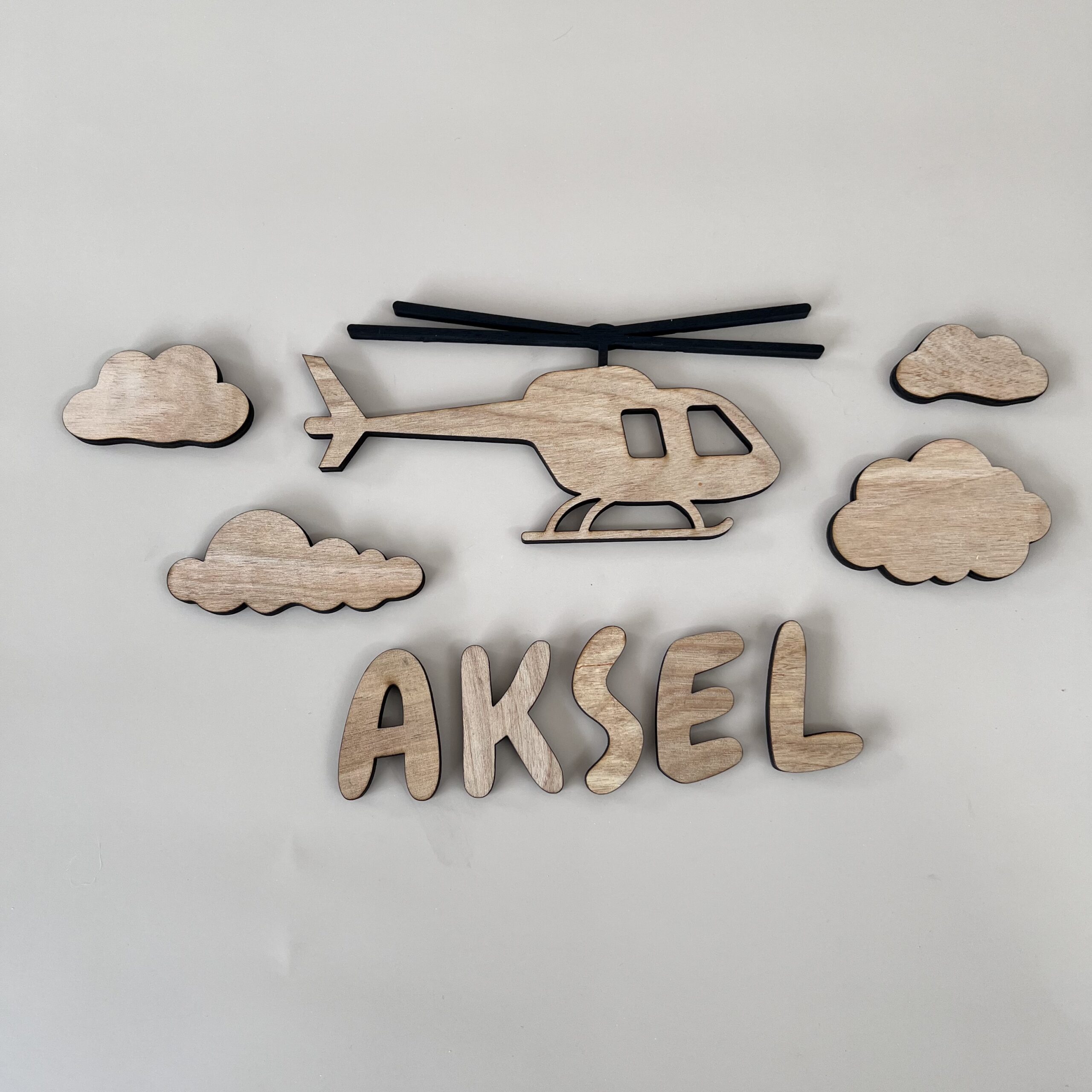 Personlig navneskilt med helikopter og 4 skyer i bjørkfiner, håndlaget av ByRossland i Bergen.