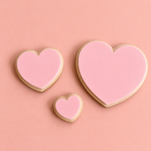 Tre hjerteformet veggdekor med rosa akryl i ulike størrelser på rosa bakgrunn.