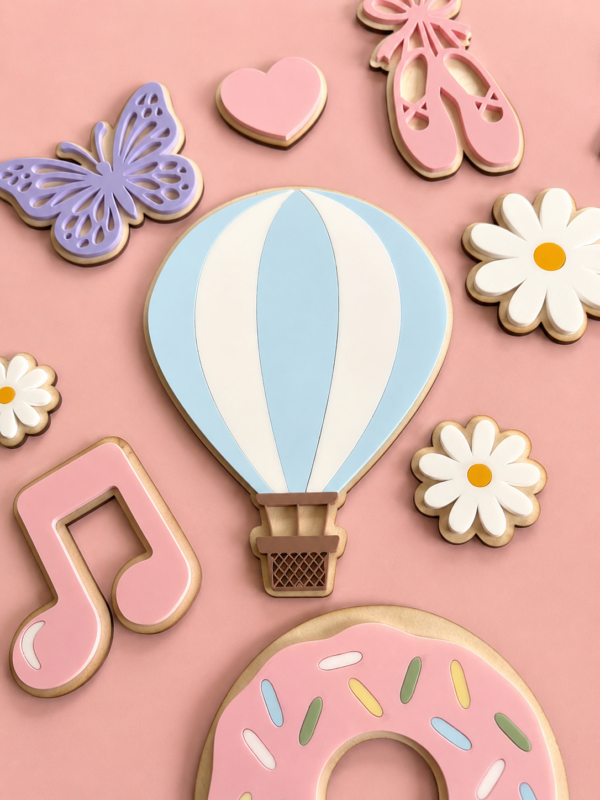 Håndlagde veggdekor til barnerom - her ser du en luftballong, musikknoter, sommerfugler, en donut, ballettsko og blomster på en lys, rosa bakgrunn.