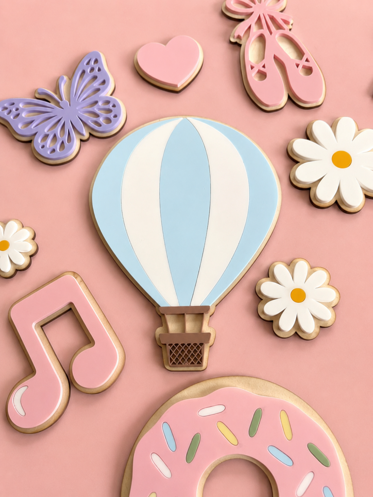 Håndlagde veggdekor til barnerom - her ser du en luftballong, musikknoter, sommerfugler, en donut, ballettsko og blomster på en lys, rosa bakgrunn.